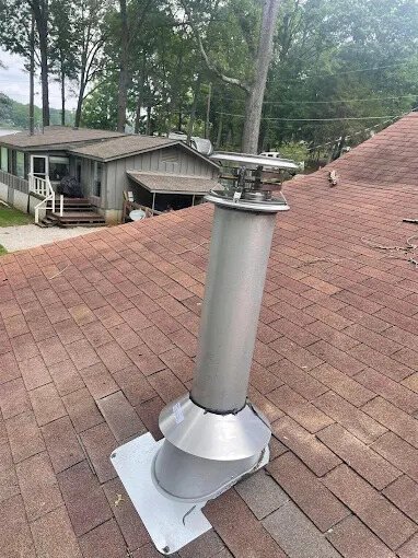 Close-up of stainless chimney pipe and roof flashing