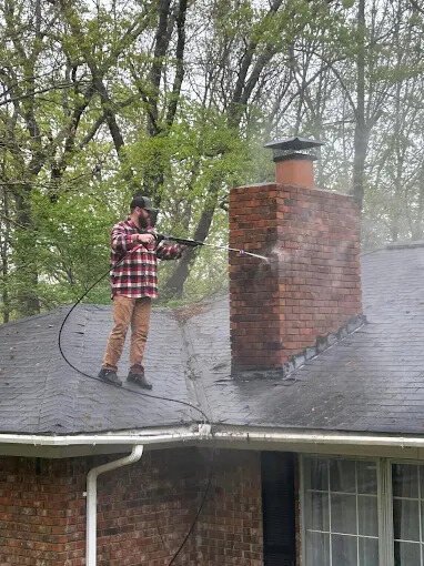 Chimney Works technician cleaning a roof and chimney near Olive Branch, MS